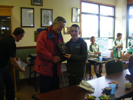 Conor Carney on behalf of local primary schools presenting the Primary Shield to the winning Coolera / Strandhill captain.