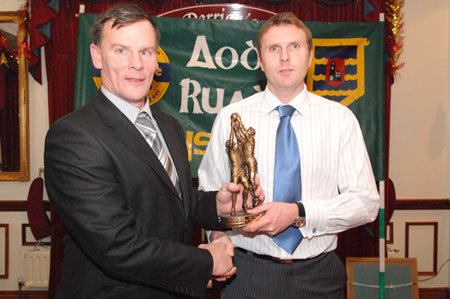 Stephen Ward receives the Senior Player of the year from Sylvester Maguire.