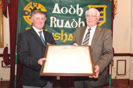 Terence McShea presenting the Hall of Fame award to PJ Buggy.