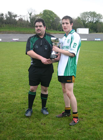 Rory McGonigle, match referee and County Hurling Board Chairman, presents the Minor Hurling Trophy to the Aodh Ruadh caption, Stephen Ryan.